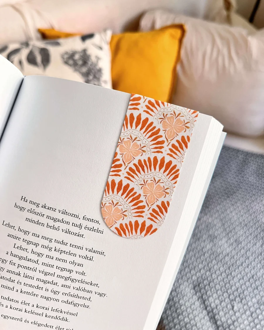 Rózsaszín és bordó boho mintás mágneses könyvjelző egy idézetes könyv oldalán, otthoni hangulatú háttérrel.